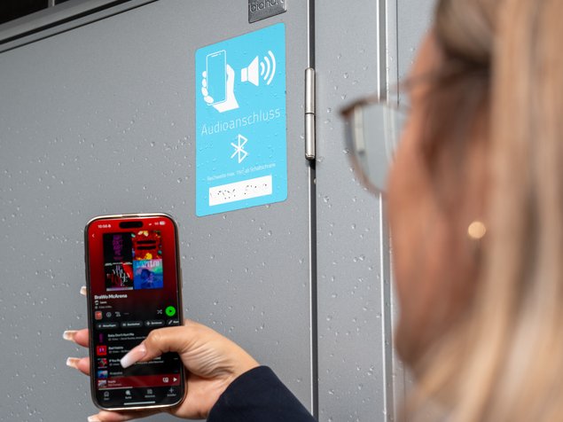 Audio- und Musikanschluss Person streamt Musik über Bluetooth auf dem Smartphone vor einem Audiosystem.